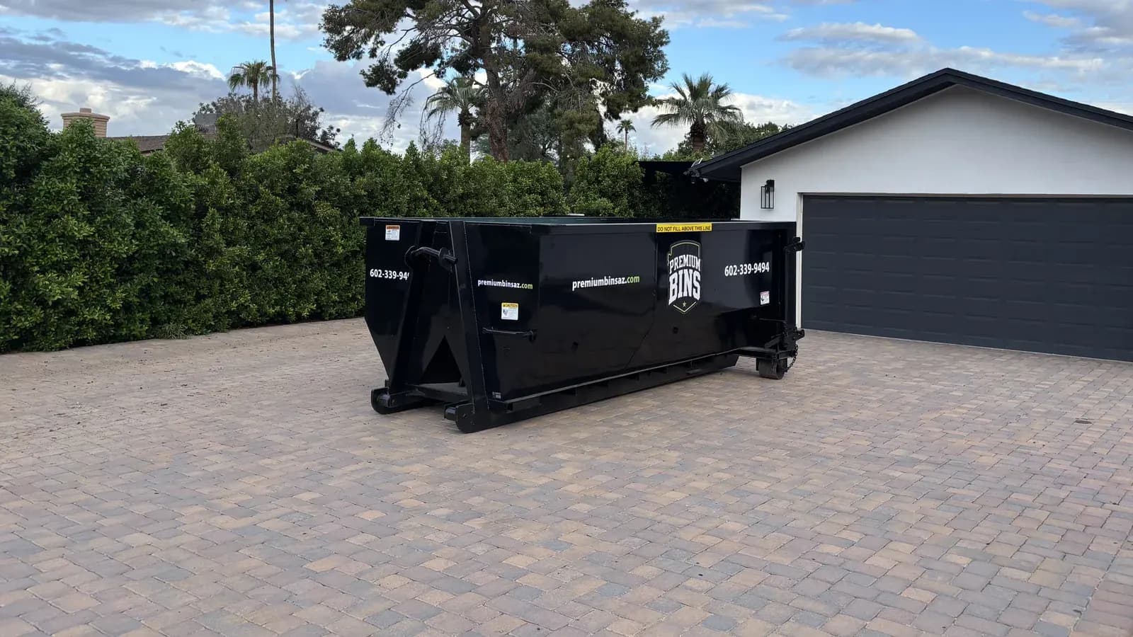 A Premium Bins 15-yard dumpster on a paver driveway in the Phoenix area